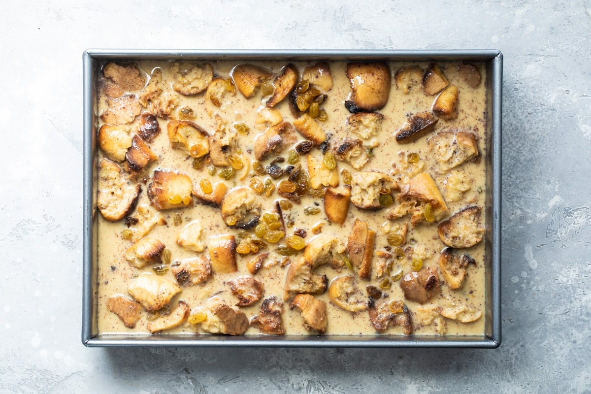 Uncooked bread pudding in a rectangle baking pan.