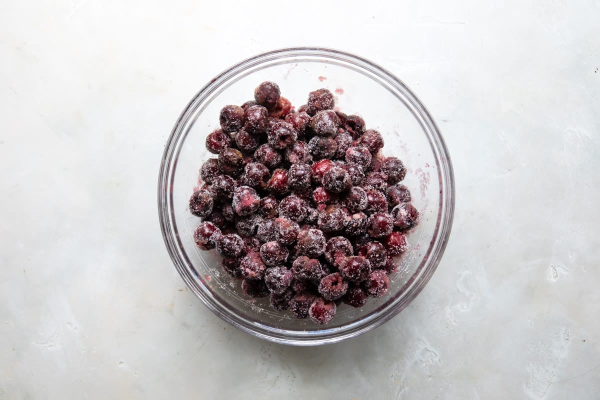 A bowl of cherries tossed with sugar and spices for cherry crisp.