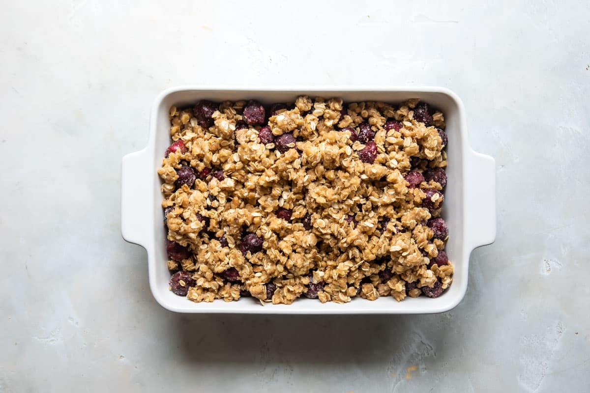 An unbaked Cherry crisp with crunchy topping.