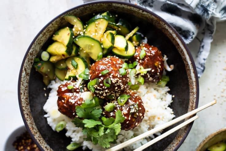 Korean barbecue meatballs, rice and cucumber in a gray bowl