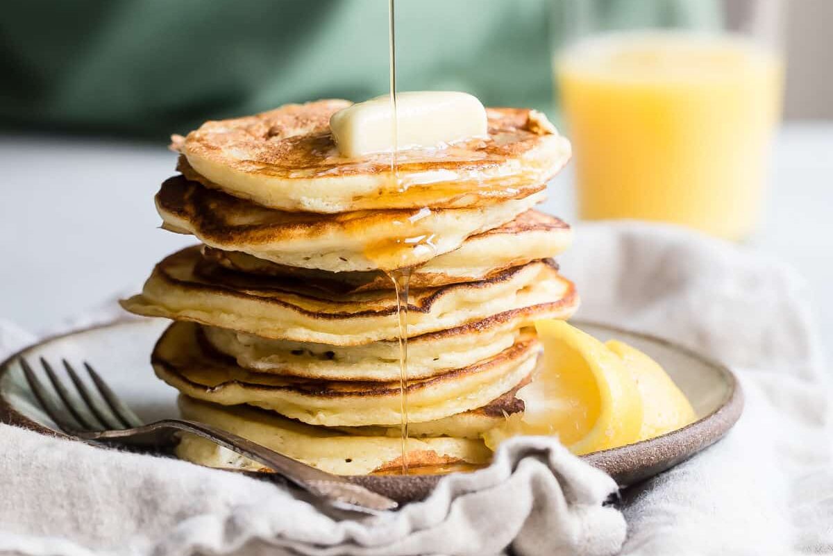 A stack of lemon ricotta pancakes on a plate.