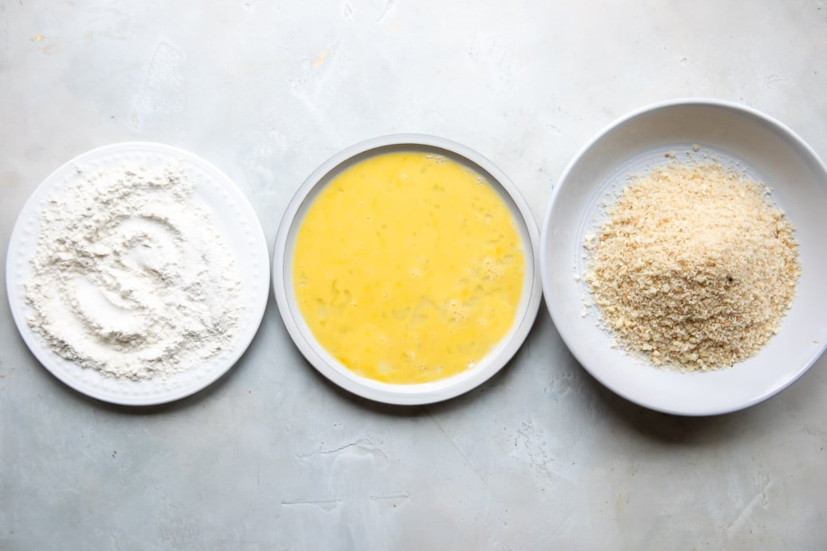 Dishes of flour, eggs, and bread crumbs for breading pork tenderloin.
