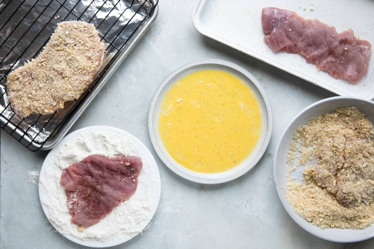 Dishes of flour, eggs, and bread crumbs for breading pork tenderloin.