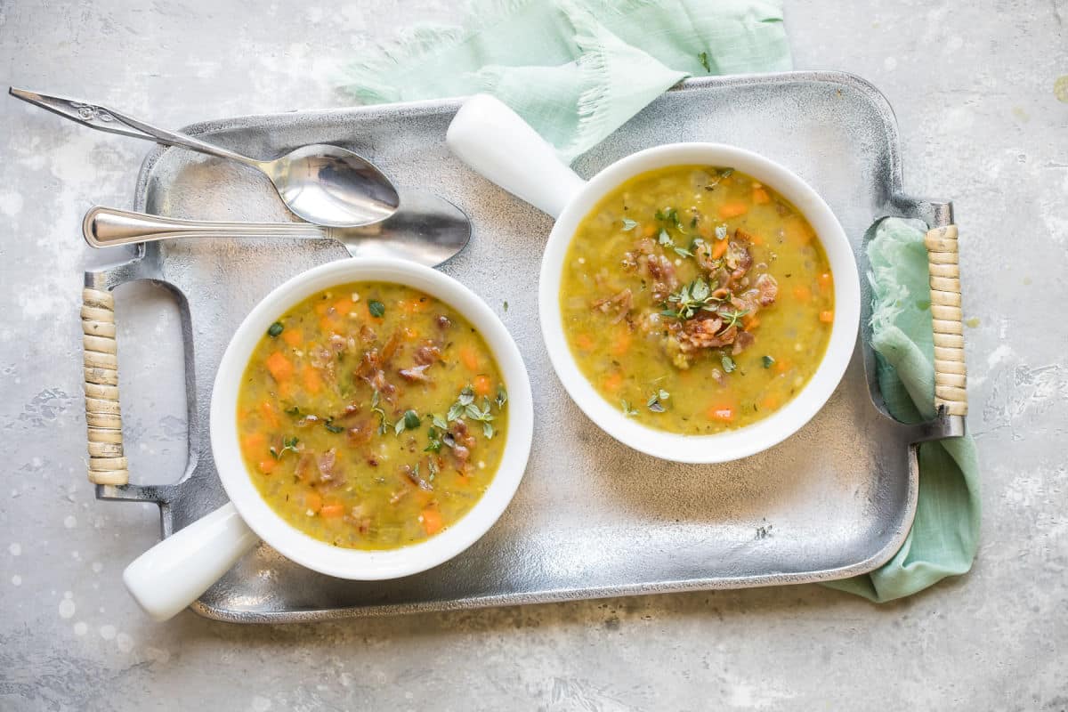 Two bowls of split pea soup on a tray.