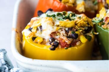 Vegetarian stuffed peppers in a white baking dish.