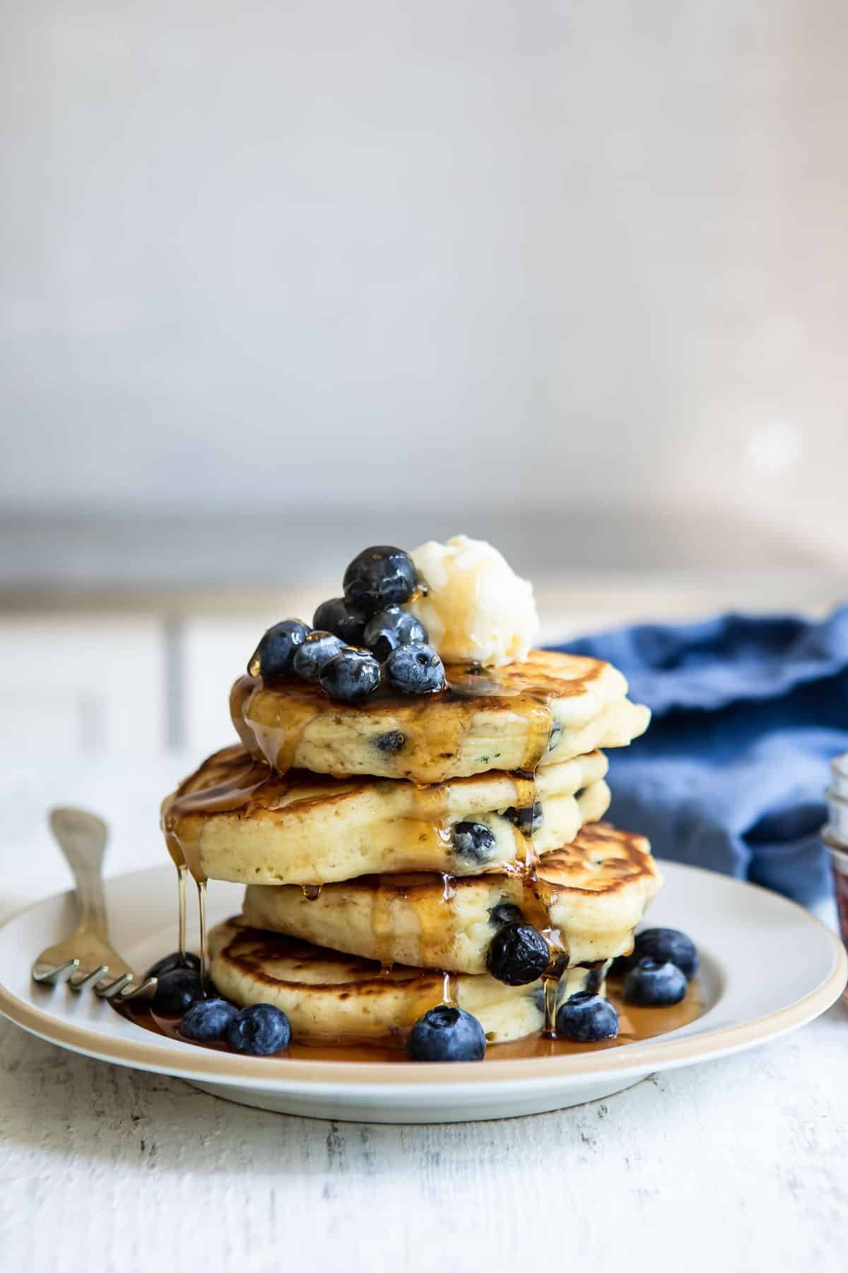 A stack of blueberry pancakes on a plate.