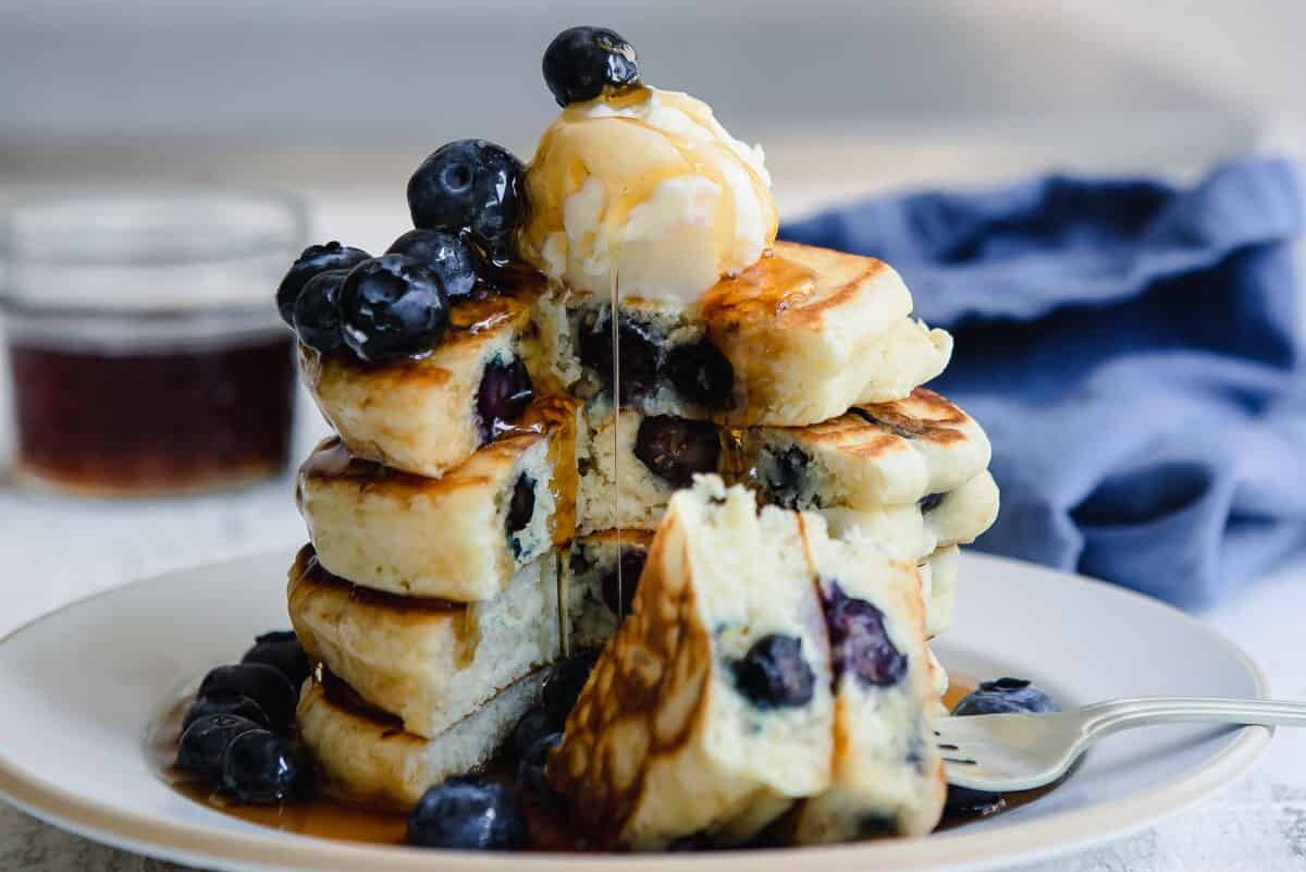 A stack of blueberry pancakes on a plate.