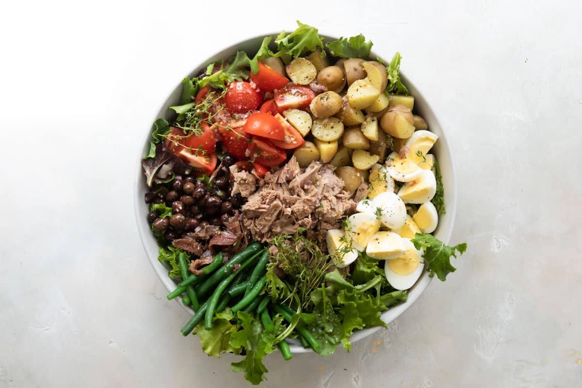 A large serving bowl with Niçoise Salad.
