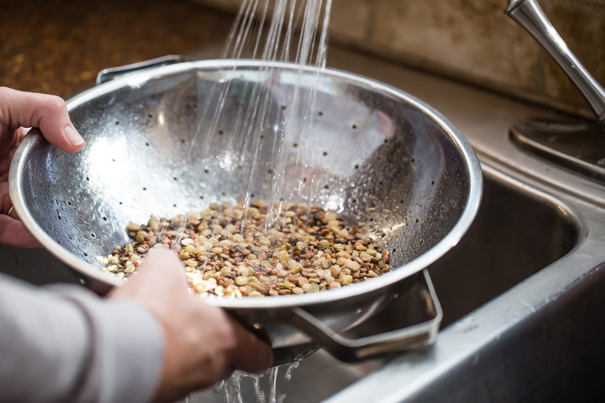 Rinsing lentils in a colander.