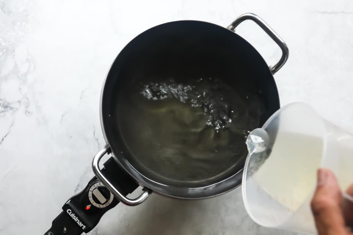 Pouring wine into a fondue pot.