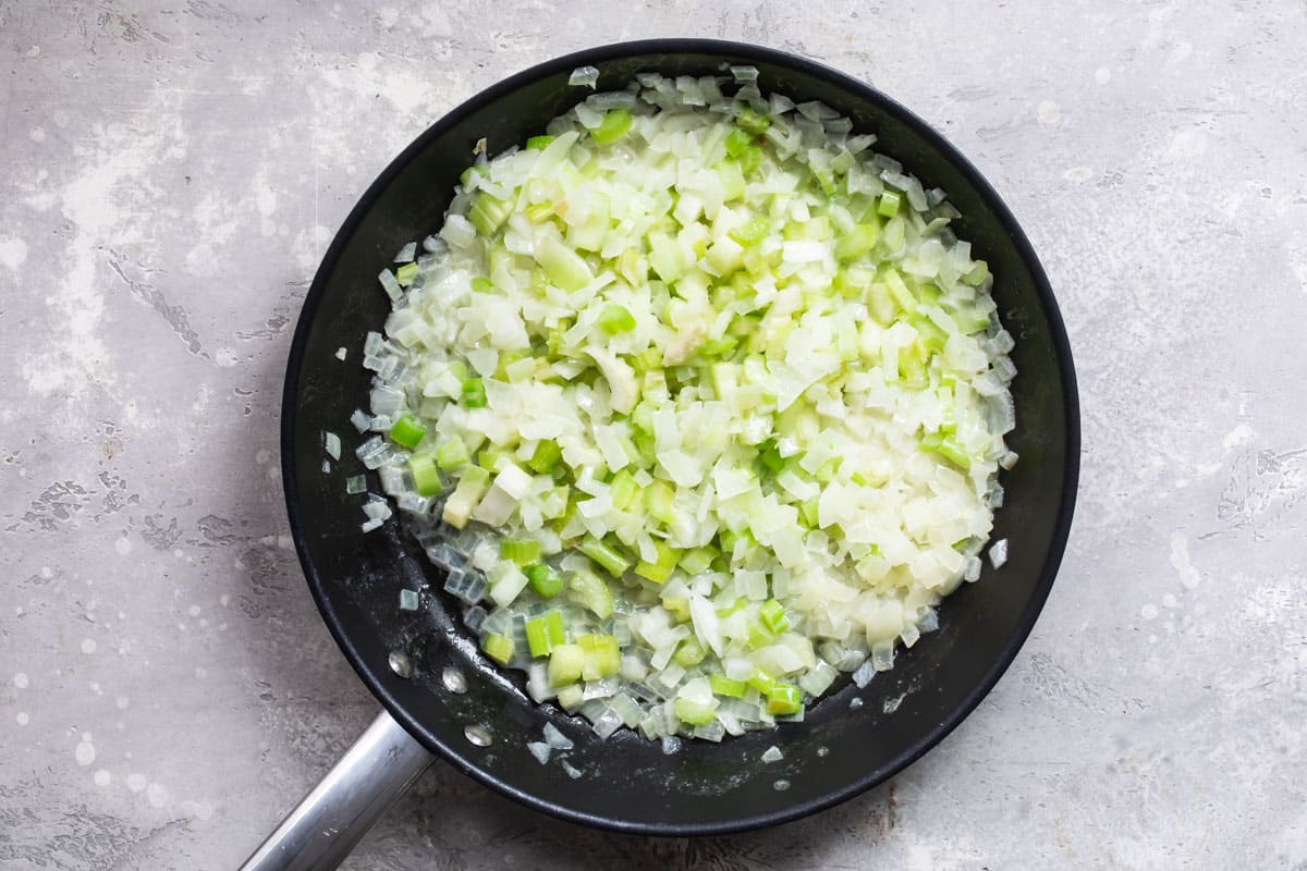 A skillet full of onion and celery.
