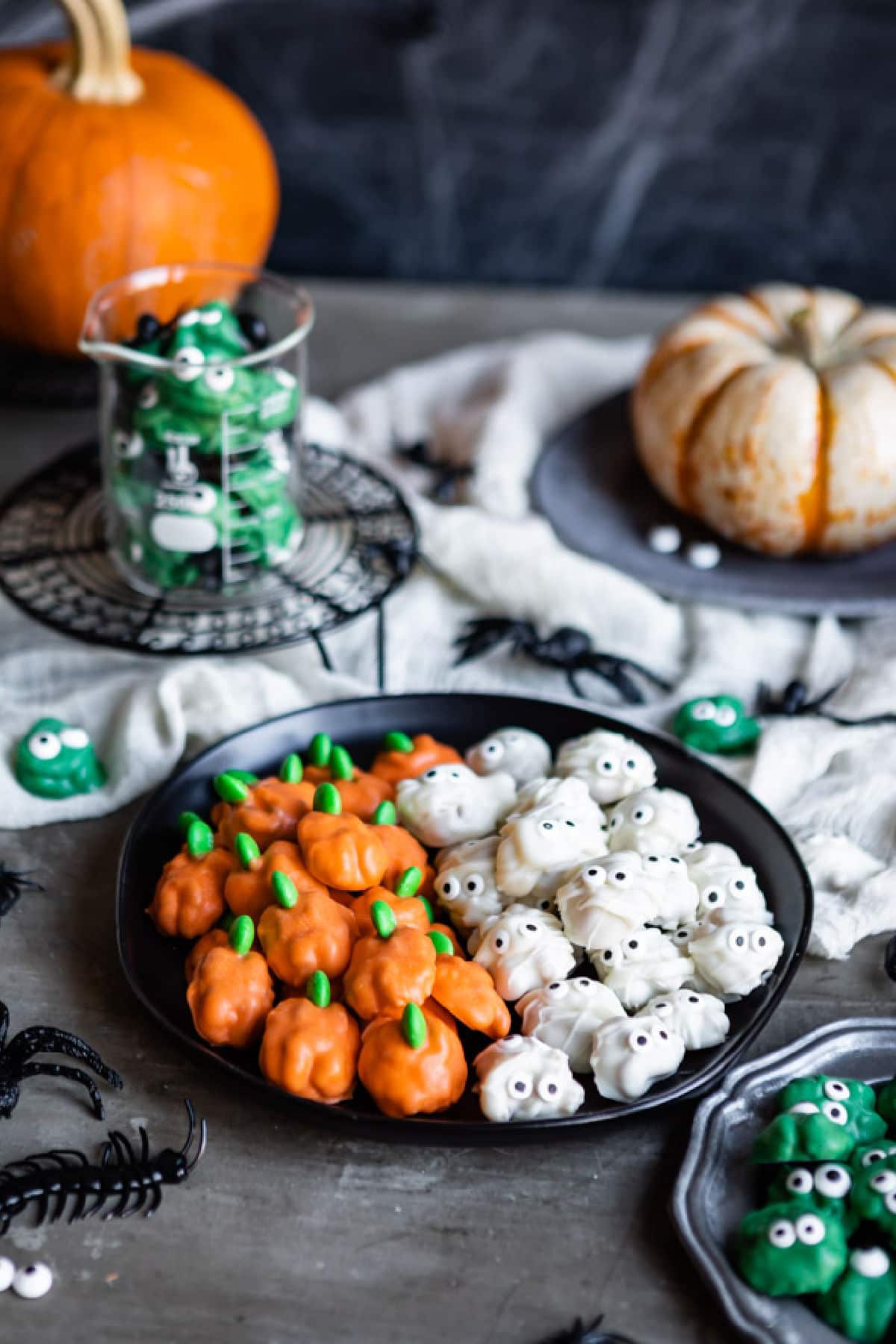 A plate of Halloween walnuts decorated to look like pumpkins and mummies.