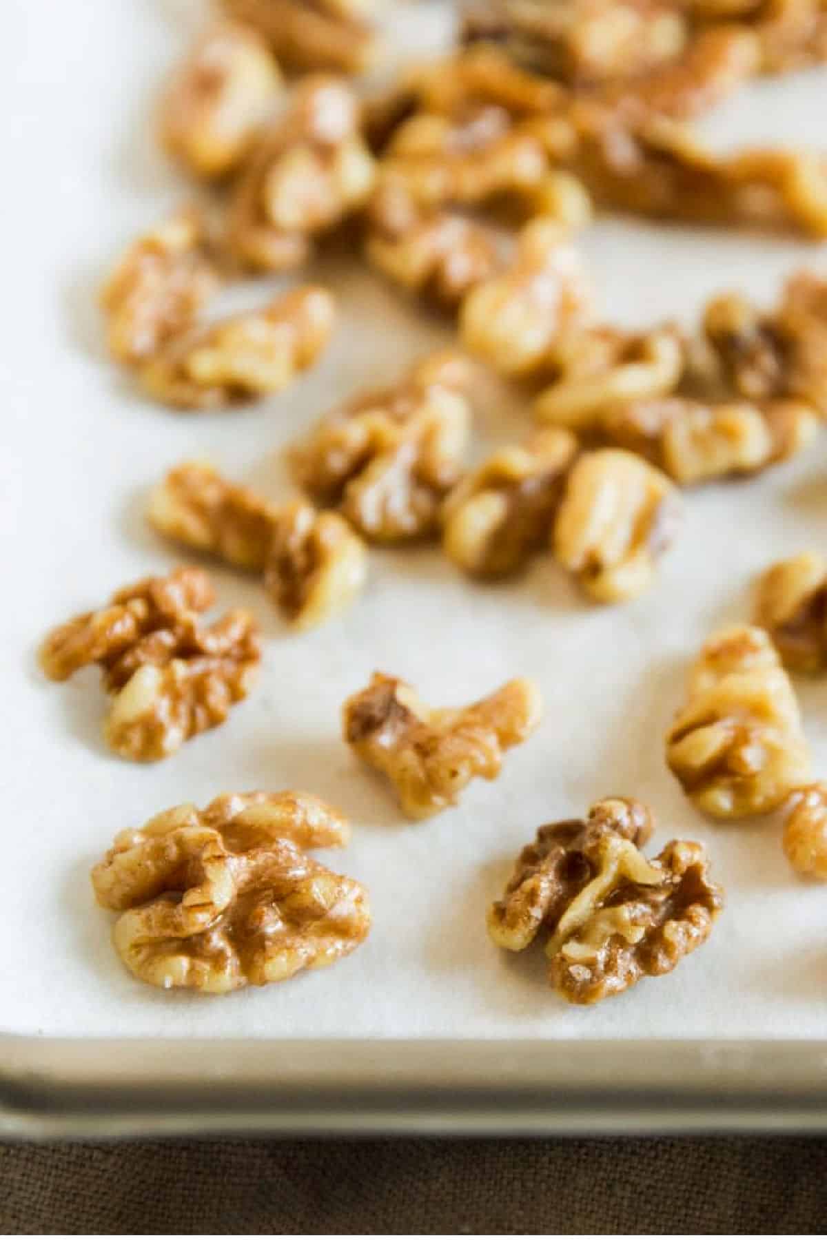 Toasted walnuts on a baking sheet.