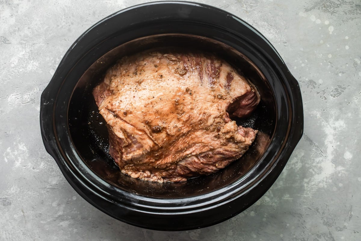 A beef brisket in a slow cooker.