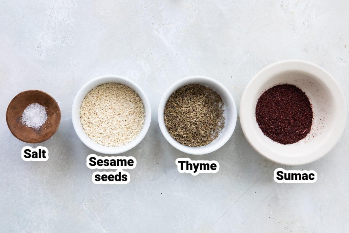 Labeled ingredients for Za'atar seasoning in four small bowls.