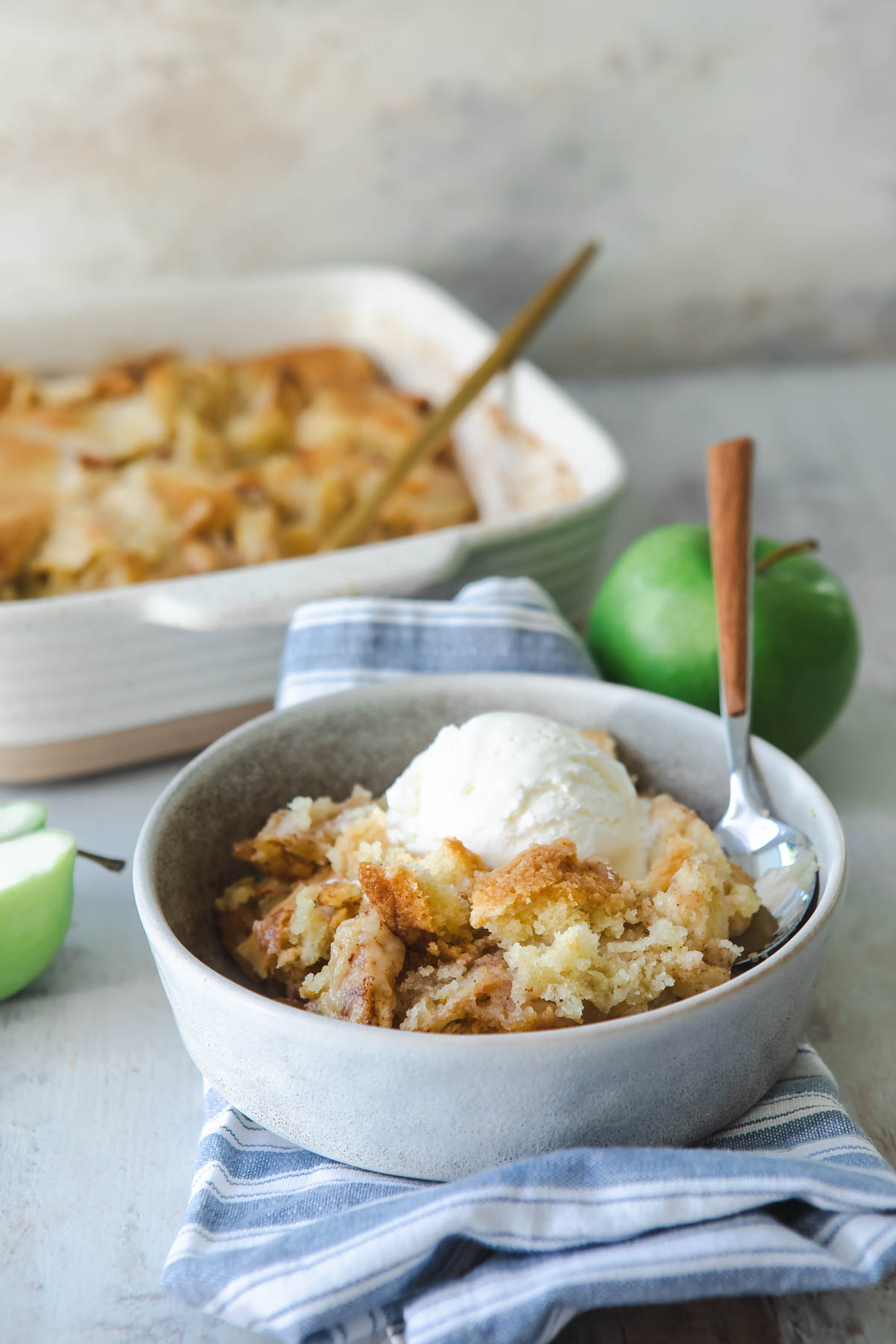A dish of apple cobbler with ice cream on top.