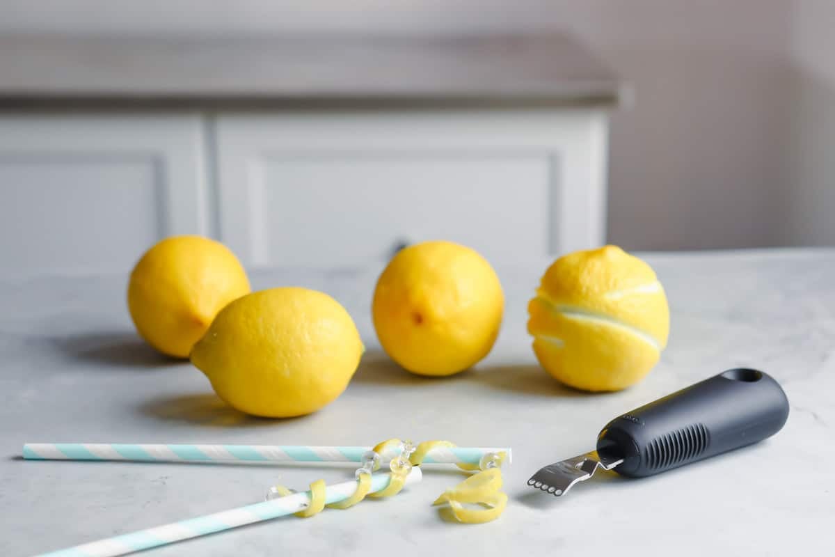 Lemons twists being made on straws.