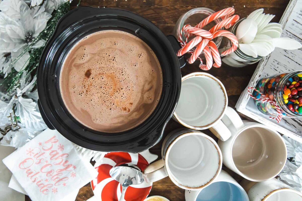A crockpot full of hot chocolate on a hot cocoa bar.