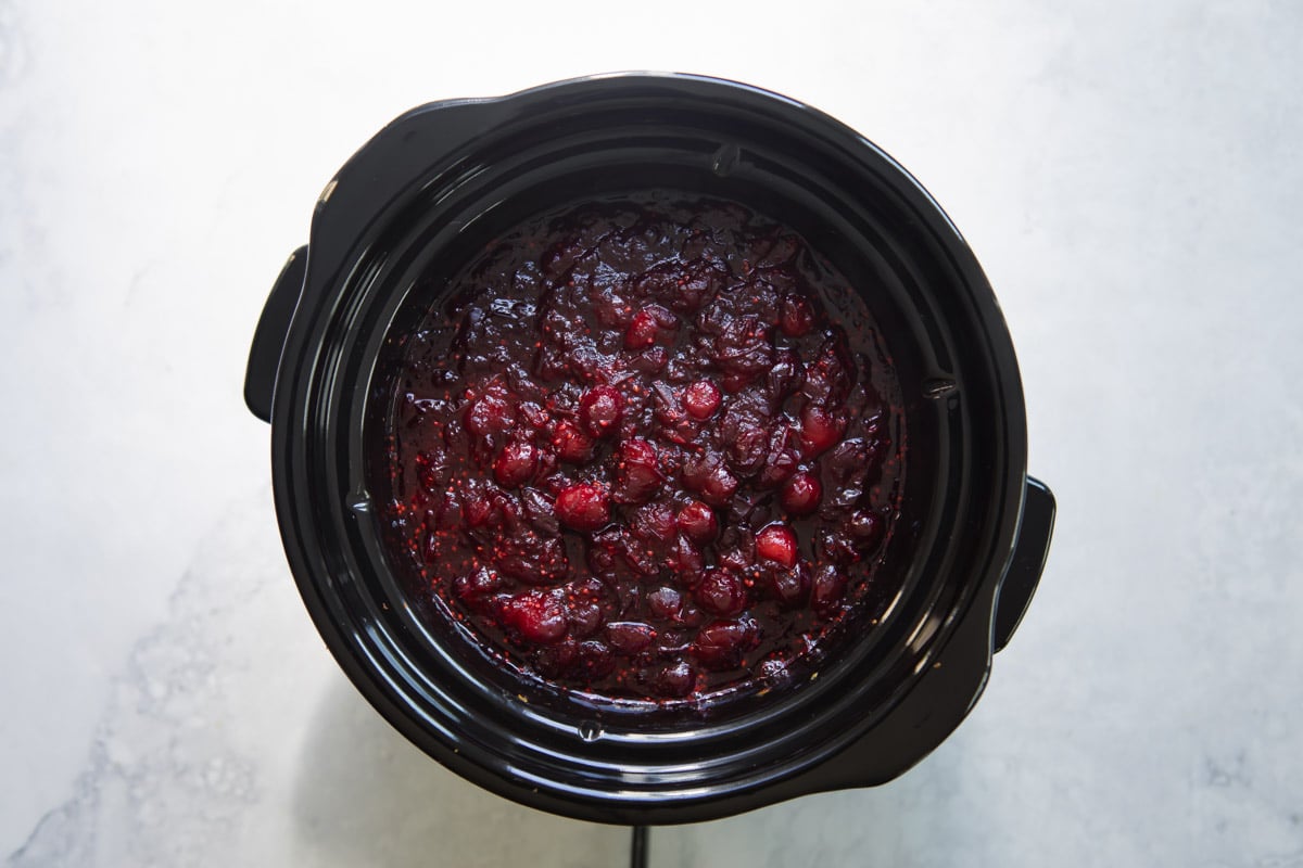 A slow cooker full of cranberry sauce.