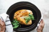 A cooked turkey breast in a crockpot.