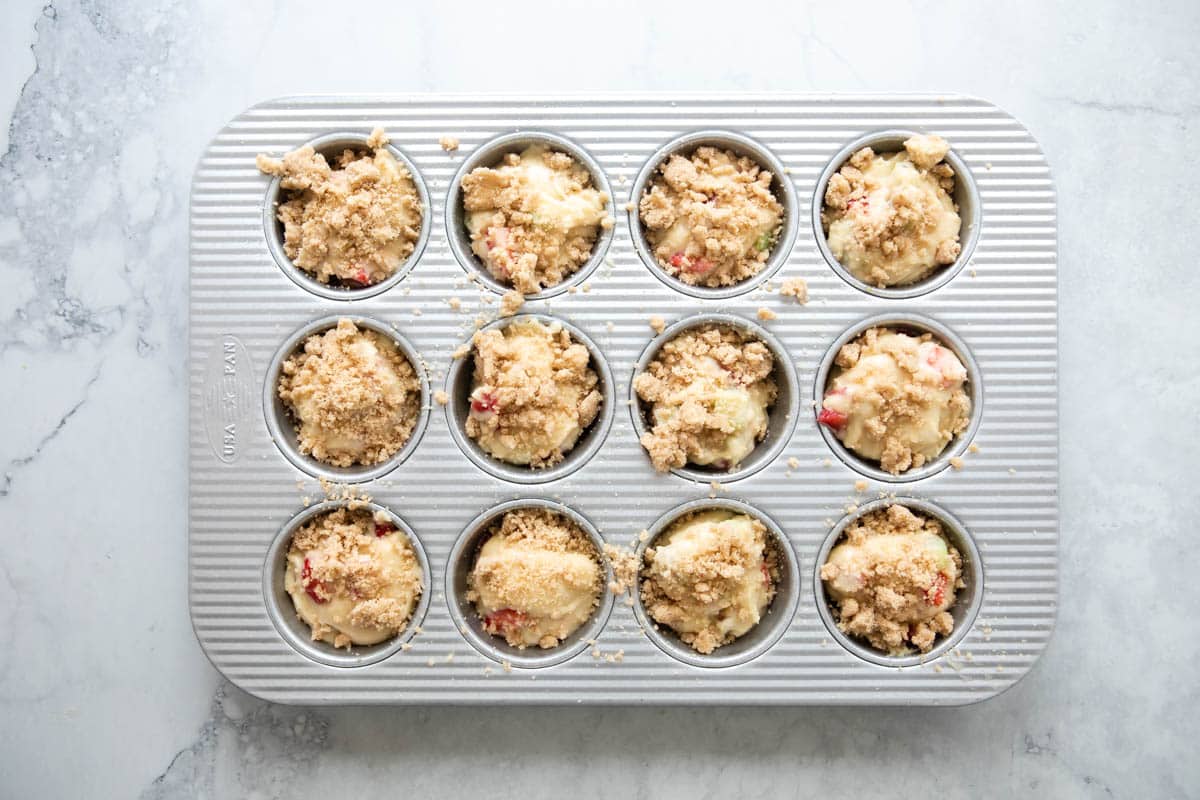 Strawberry rhubarb muffins in a muffin pan before being baked.