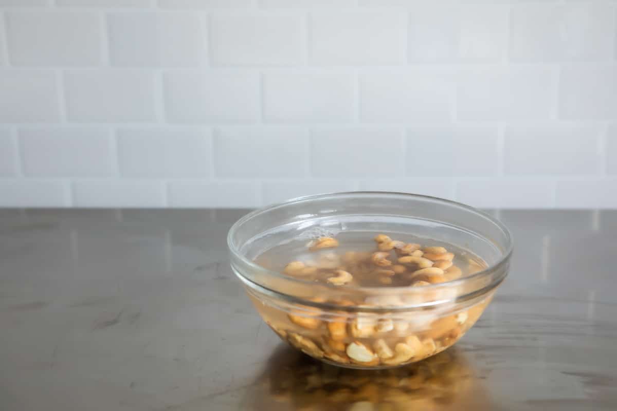 A bowl of raw cashews soaking in water.