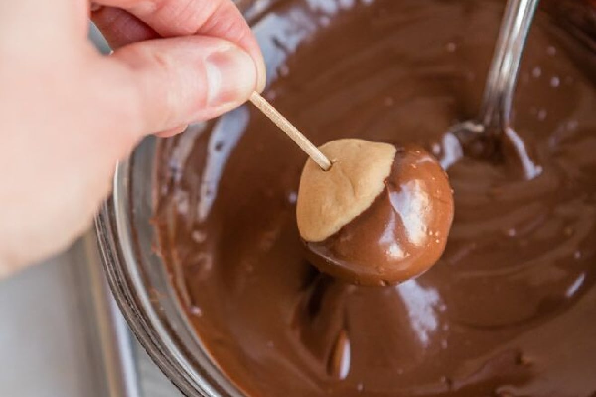 Dipping buckeyes in melted chocolate.