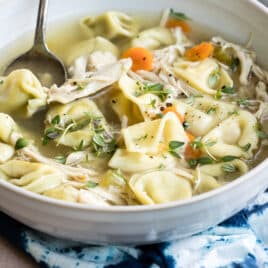 Slow cooker chicken tortellini soup in a white bowl.