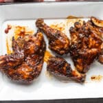 Barbecue chicken on a white platter.