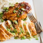 Two honey garlic chicken breasts on a platter with rice.