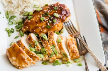 Two honey garlic chicken breasts on a platter with rice.