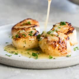Lemon garlic butter sauce drizzled over seared scallops.