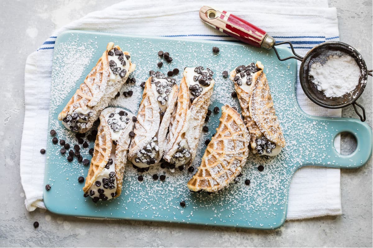 Filled pizzelle cannoli dusted with powdered sugar.