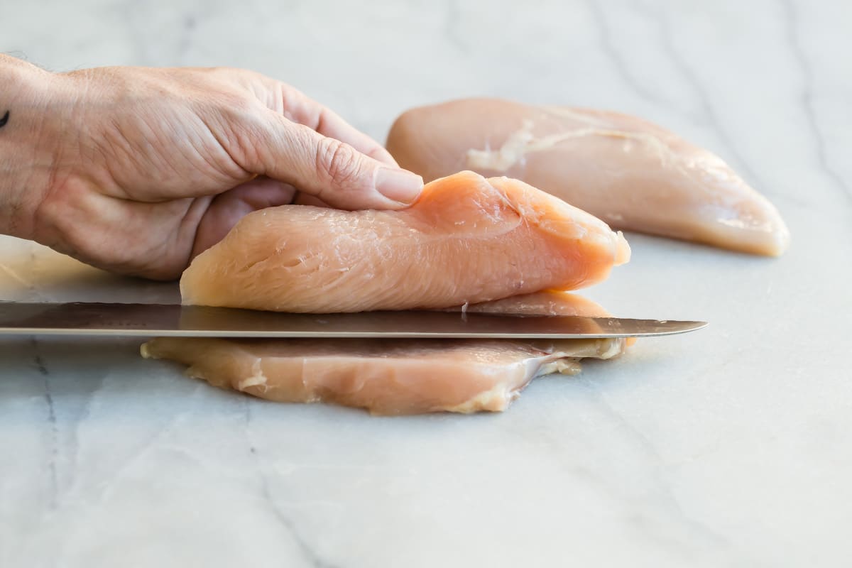 Butterflying a chicken breast into 2 cutlets.