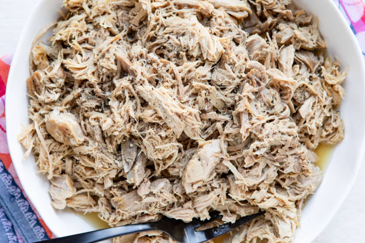 Shredded cooked carnitas in a bowl.