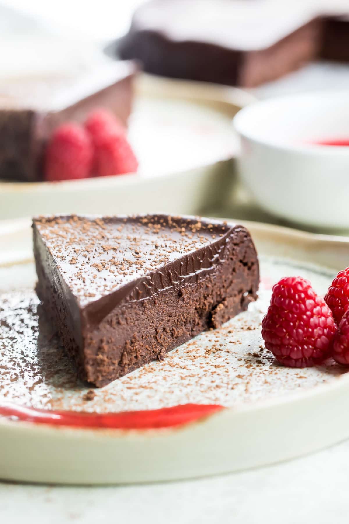 Flourless chocolate cake slice on a white plate.