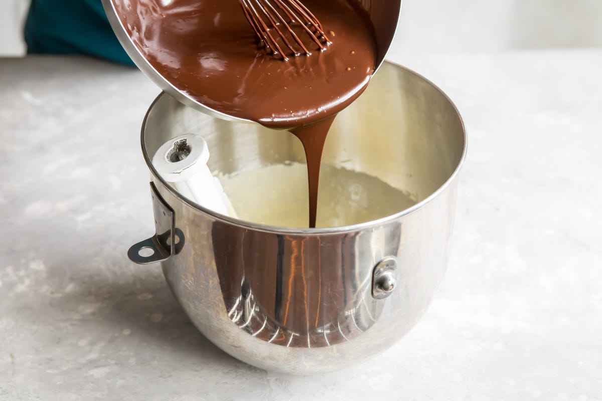 Flourless chocolate cake ingredients being combined in a silver bowl.