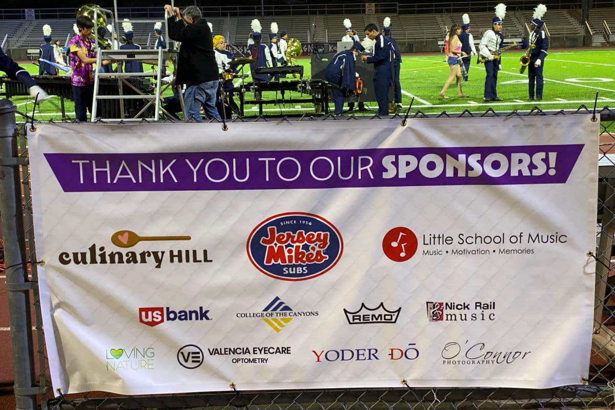 A banner showing culinary hill sponsored a high school marching band.