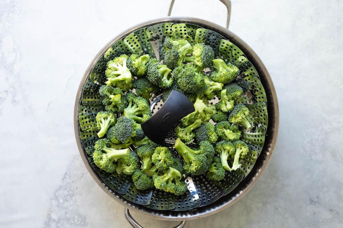 A steamer basket full of broccoli.