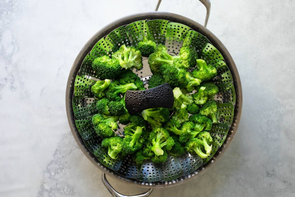 A steamer basket full of broccoli.