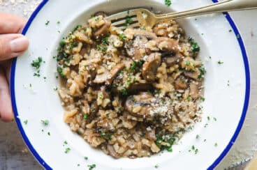 A white bowl full of mushroom risotto.