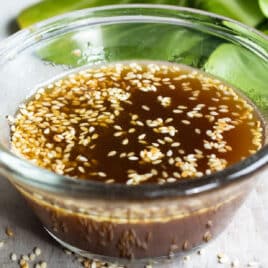 Sesame dressing in a clear bowl on a countertop.