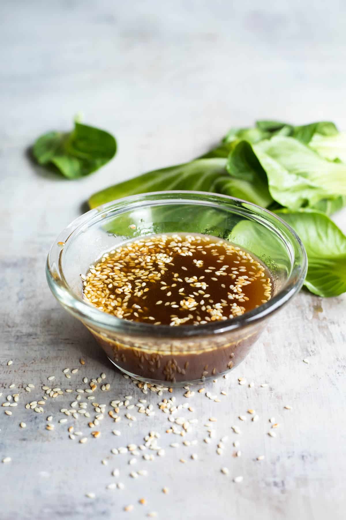 Sesame dressing in a clear bowl on a countertop.