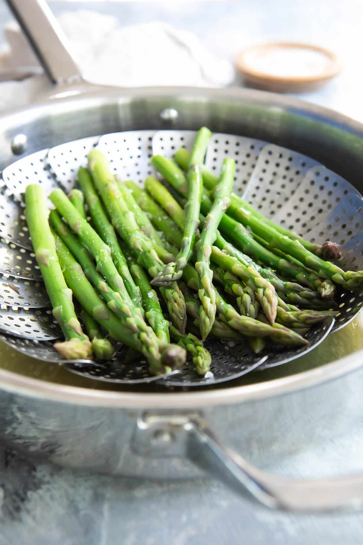 Steamed asparagus in a steamer basket.