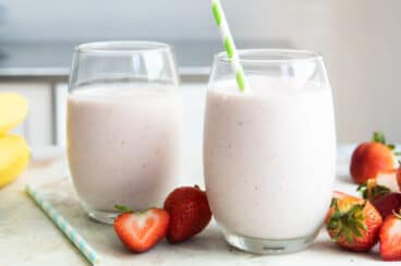 Two strawberry banana smoothies in glasses.