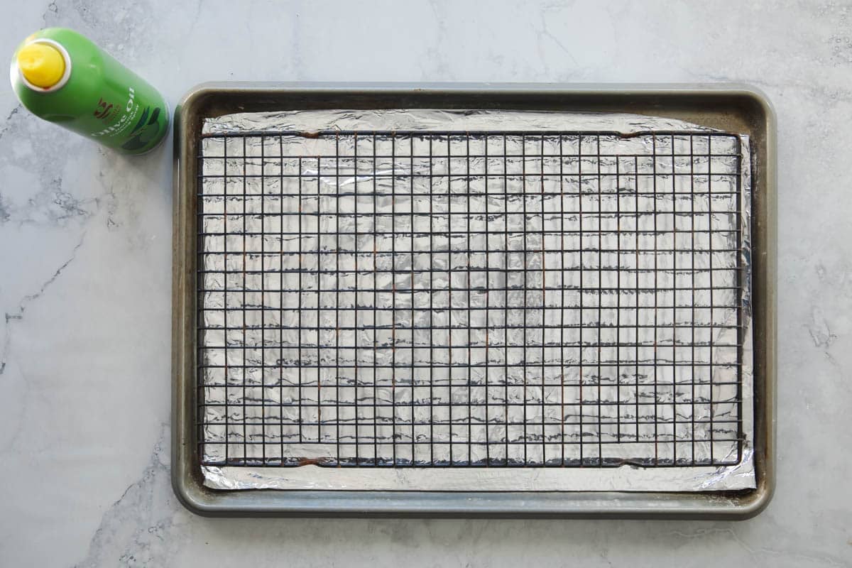 A baking rack set over a rimmed baking sheet lined with foil.