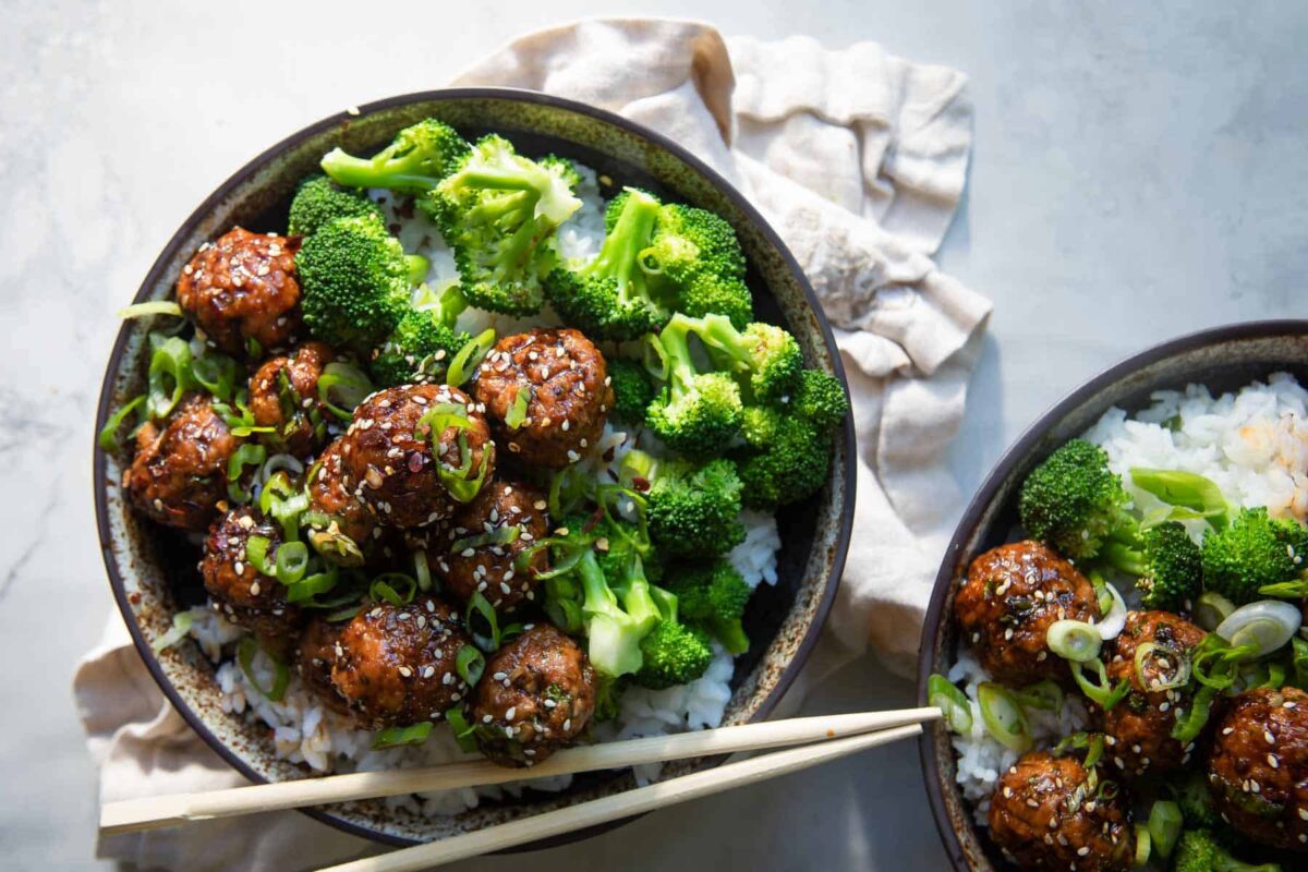 A bowl of Teriyaki meatballs over rice with broccoli.