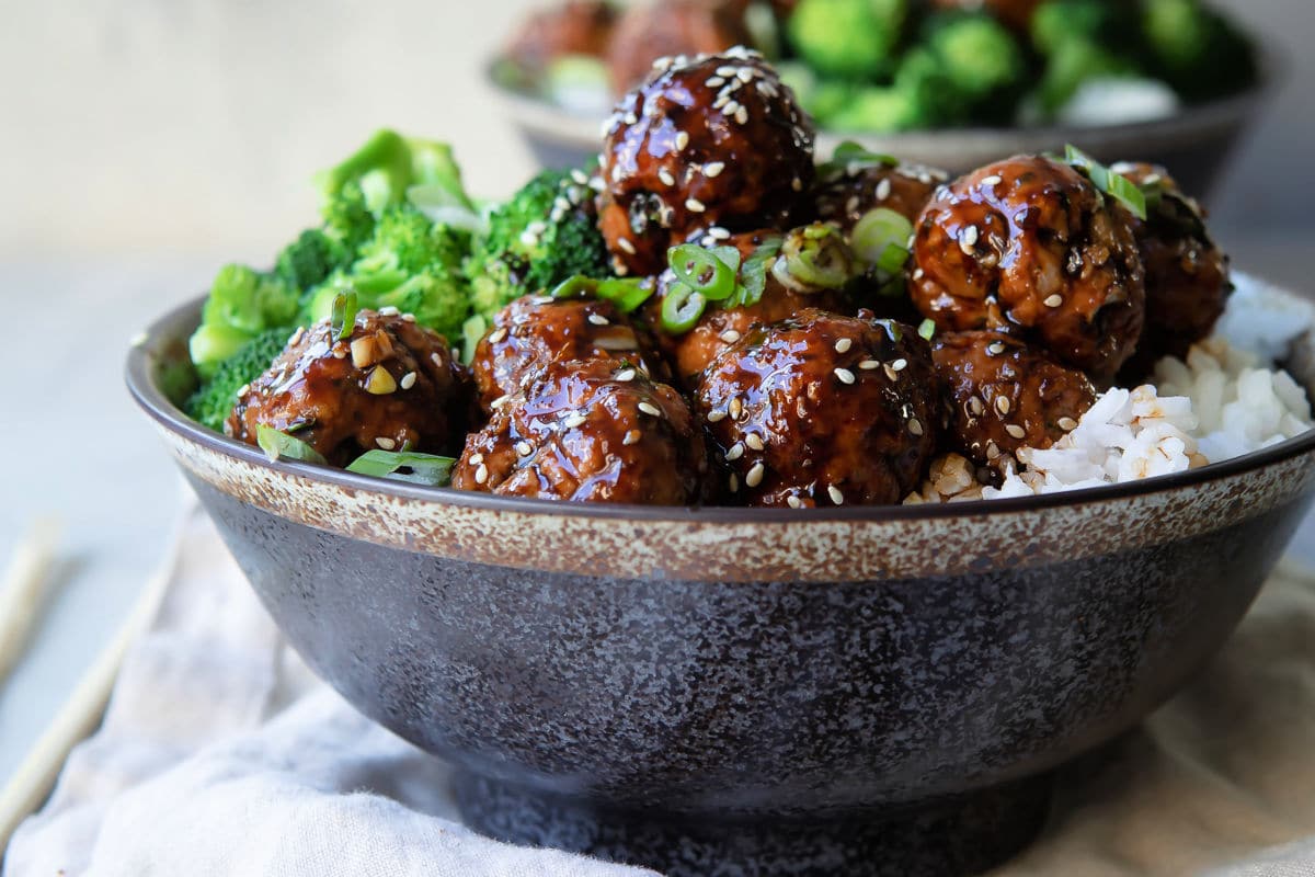 A bowl of Teriyaki meatballs over rice with broccoli.