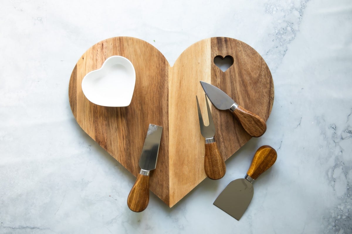 A board and tools for a Valentine's Day charcuterie board.