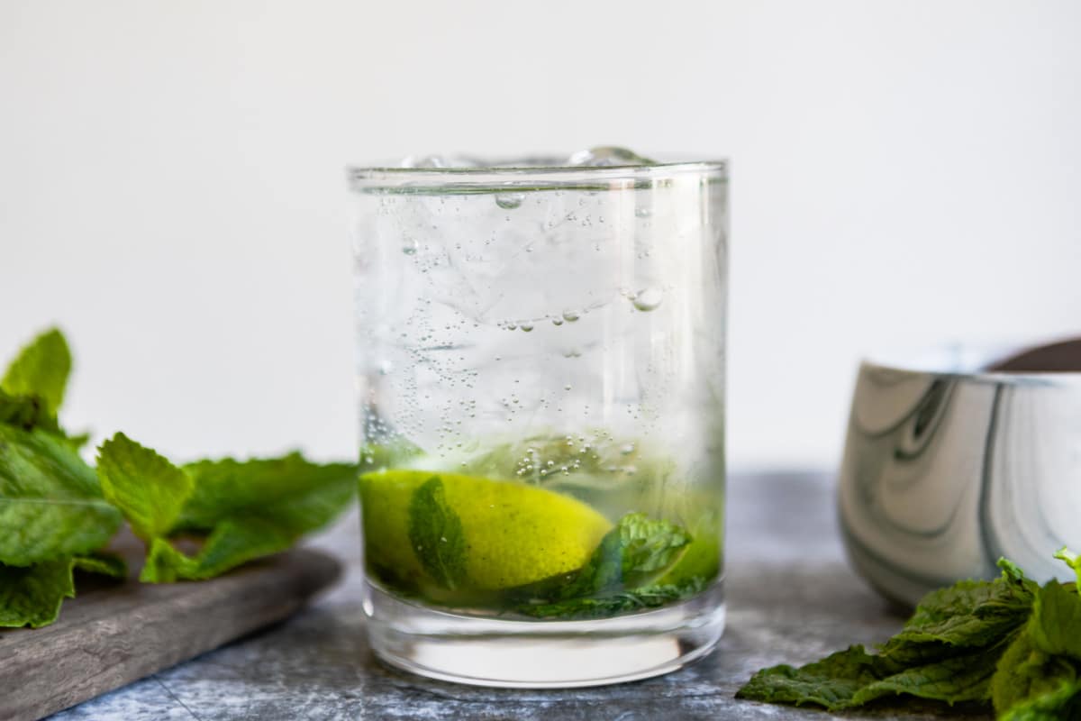 A virgin mojito mocktail in a clear glass.